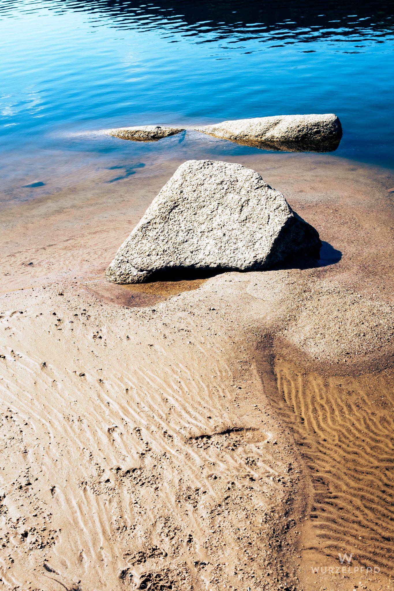 Steine am sandigen Ufer